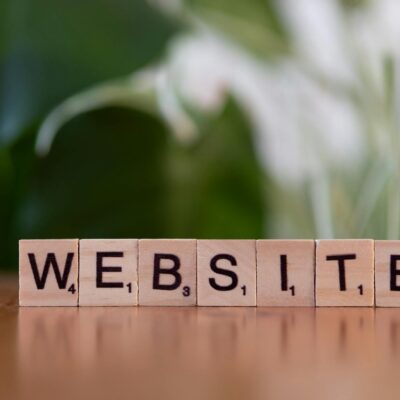 Scrabble tiles on a wooden surface forming the word 'Website', symbolizing digital communication.